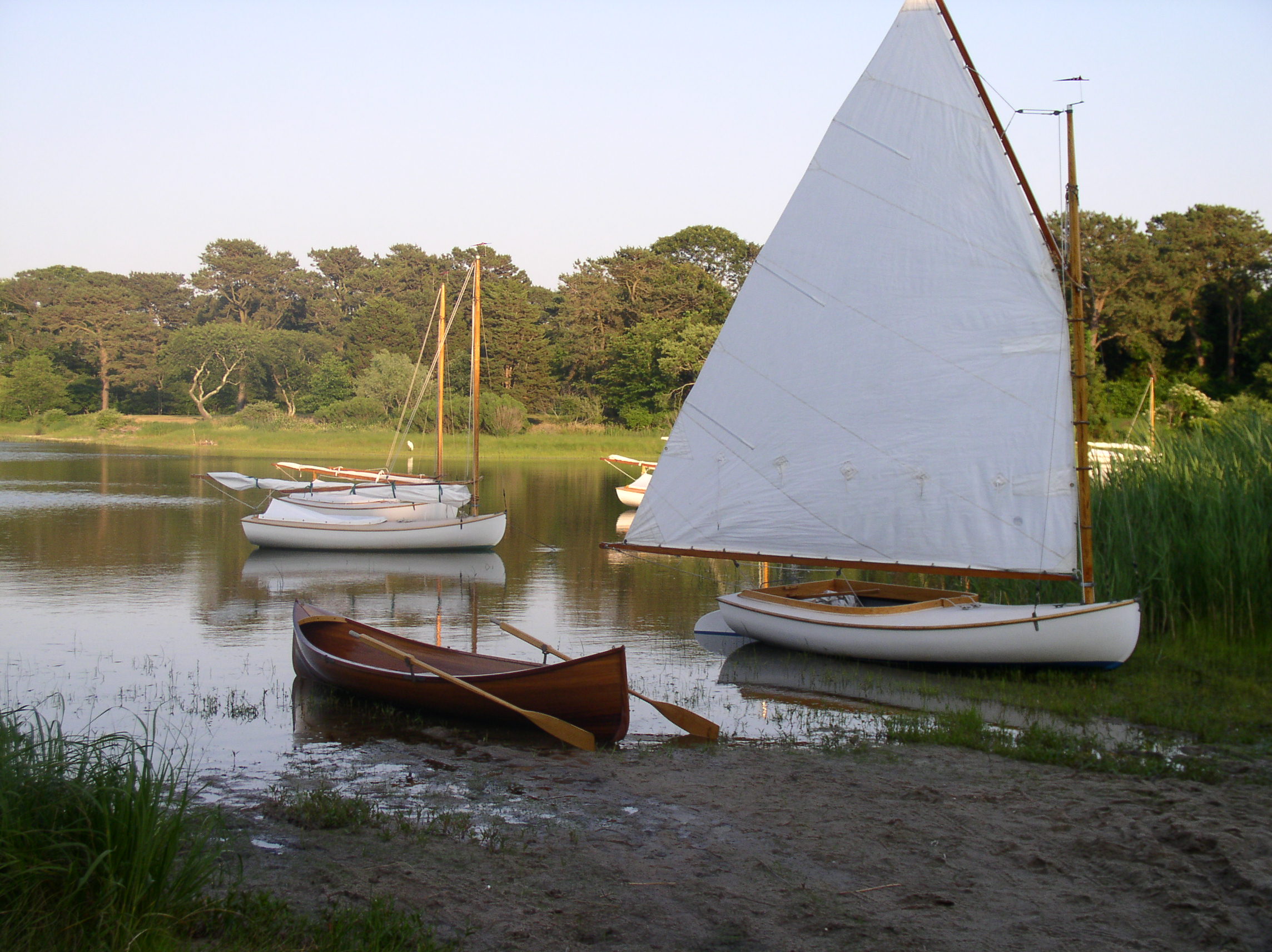 Jim’s custom made Adirondack Guideboat (left). Maintaining the Beetle Cat sailboats (right) are also part of Ancora Yacht Services business.